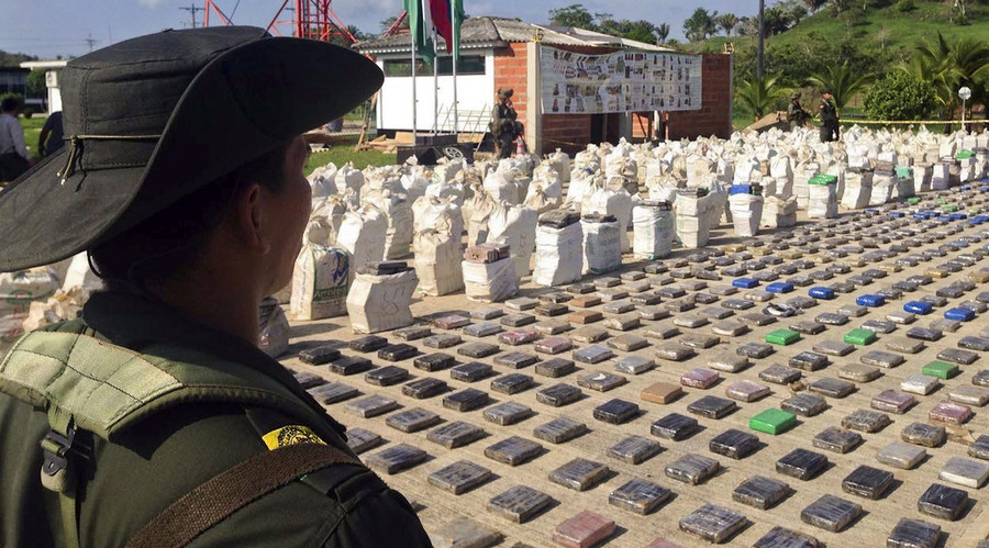 A Colombian police officer standing guard over eight tons of seized cocaine in Turbo, Antioquia department, on May 15, 2016.  Colombian police